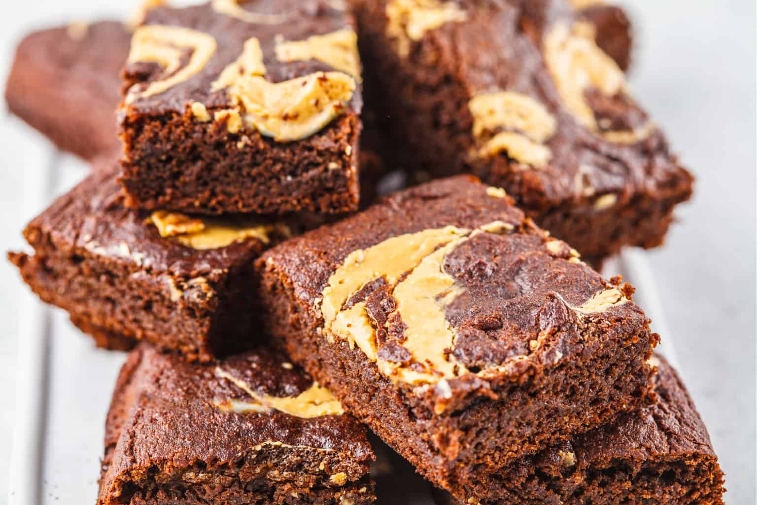 keto peanut butter brownies stacked on a white plate