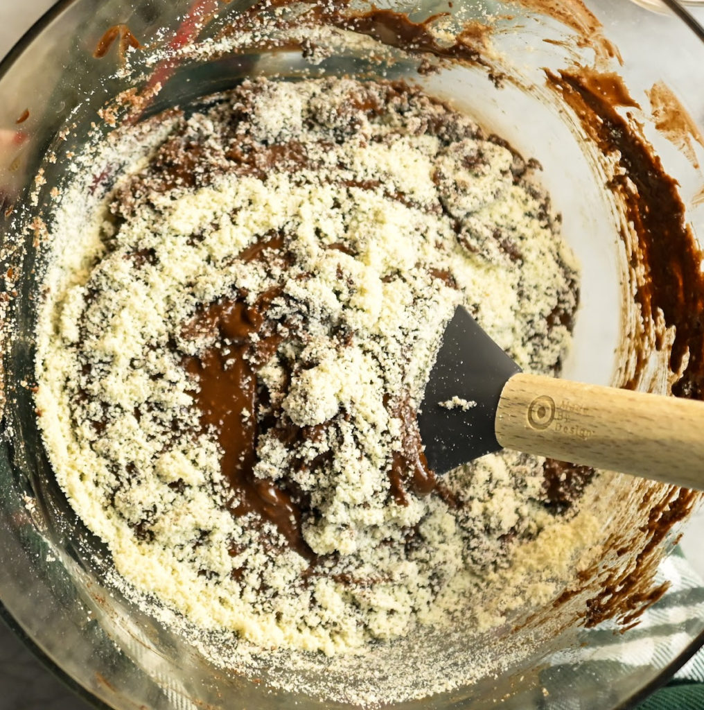 Almond flour being folded into a keto brownie batter