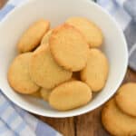 keto vanilla wafers in a white bowl with a blue and white cloth napkin next to it