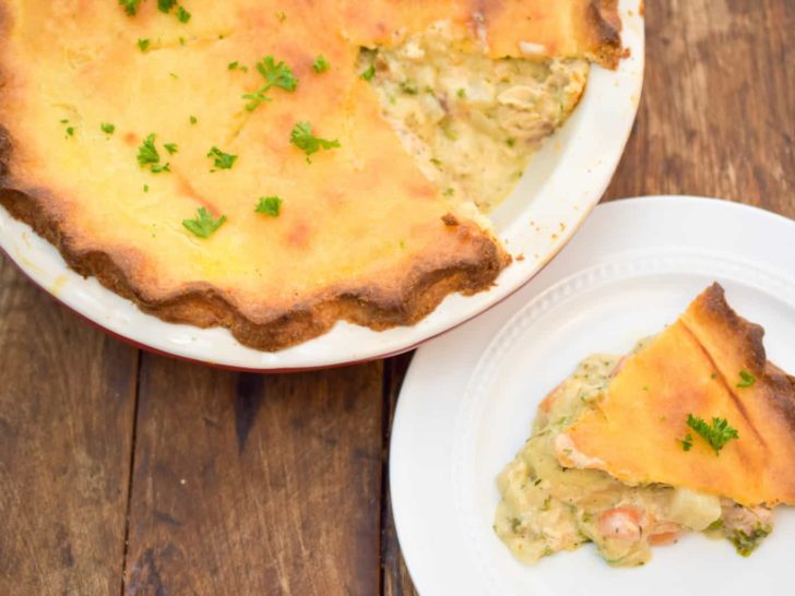 keto chicken pot pie sliced and ready to serve pie is on top of a wood table and pie is served on a white plate