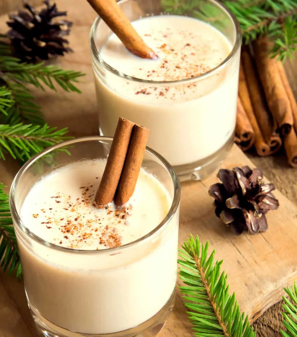 keto eggnog served in two clear glasses with cinnamon sticks