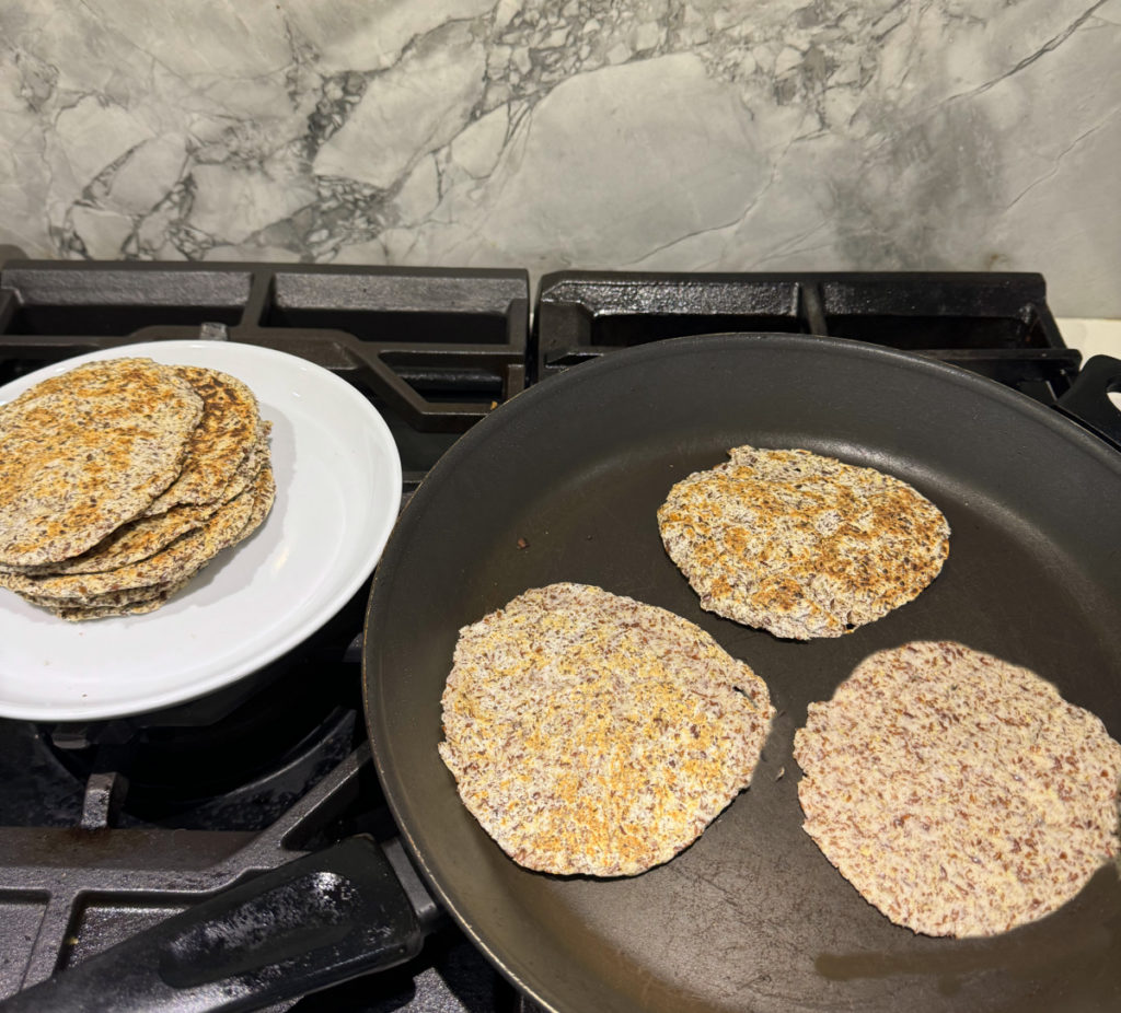 keto tortillas being cooked on non-stick skillet