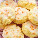 keto orange cookies on a pink clear plate stand