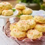 keto orange cookies on pink glass plate and white pedestal in the background