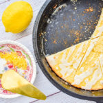 keto lemon ricotta scones in cast iron skillet with dish of lemon zest and lemon on the left