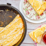 keto lemon ricotta scones in cast iron skillet with more scones on pink and white plates on the right