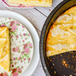 keto lemon ricotta scones in cast iron skillet with scone on pink floral plate