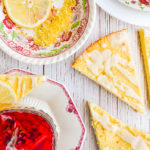 keto lemon ricotta scones on wood table surrounded by assorted dishes and tea