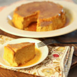 keto pumpkin flan sliced and ready to serve on a wood board with a fall napkin underneath