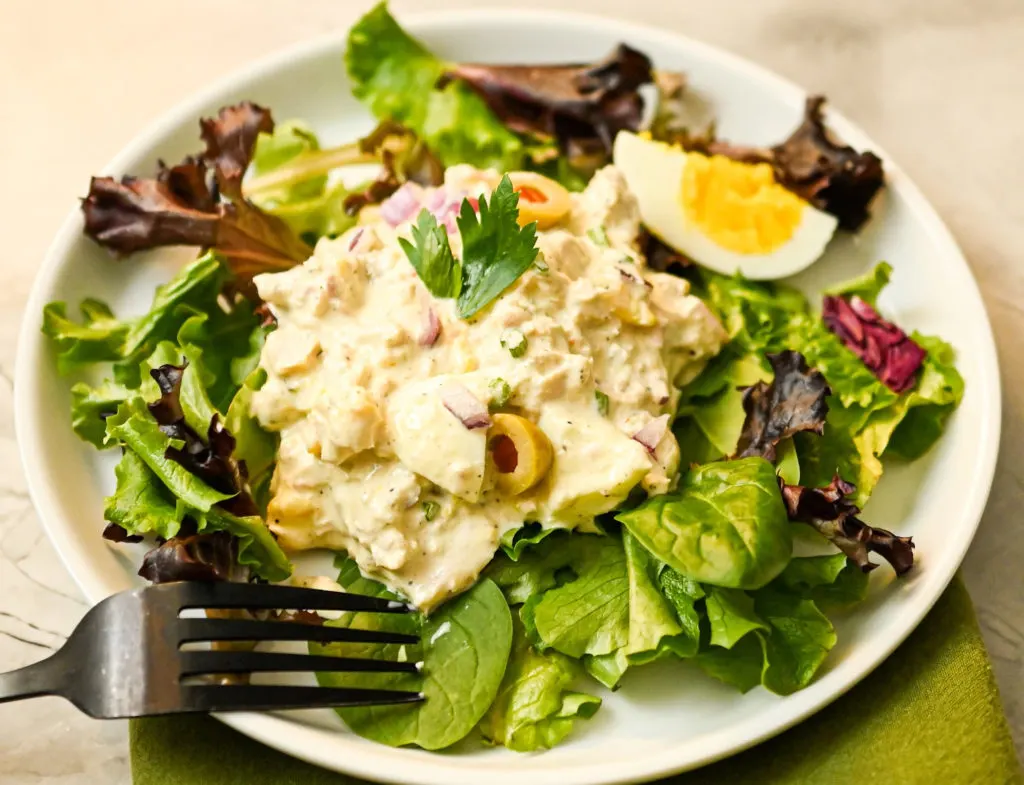 tuna and egg salad served on a bed of spring greens