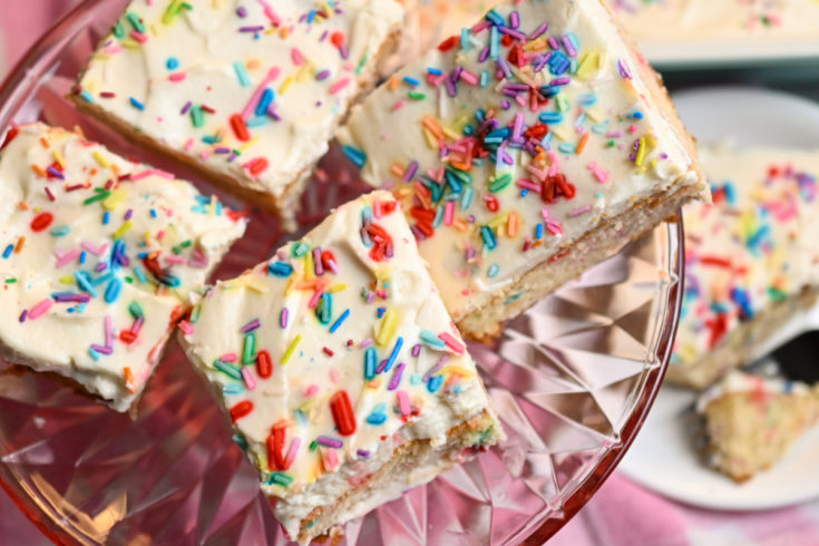 Keto Birthday Cake funfetti slices on a clear pink pedestal stand