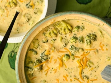 Keto broccoli cheese soup made in a crockpot and served in a green soup tureen and a white bowl