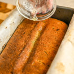 keto coconut flour zucchini bread backed and being drizzled with melted butter for more flavor