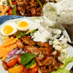 keto-friendly blue cheese dressing being poured over a keto Cobb salad