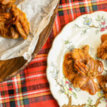 keto pralines on white floral plate and parchment paper on wood board on red plaid napkin_