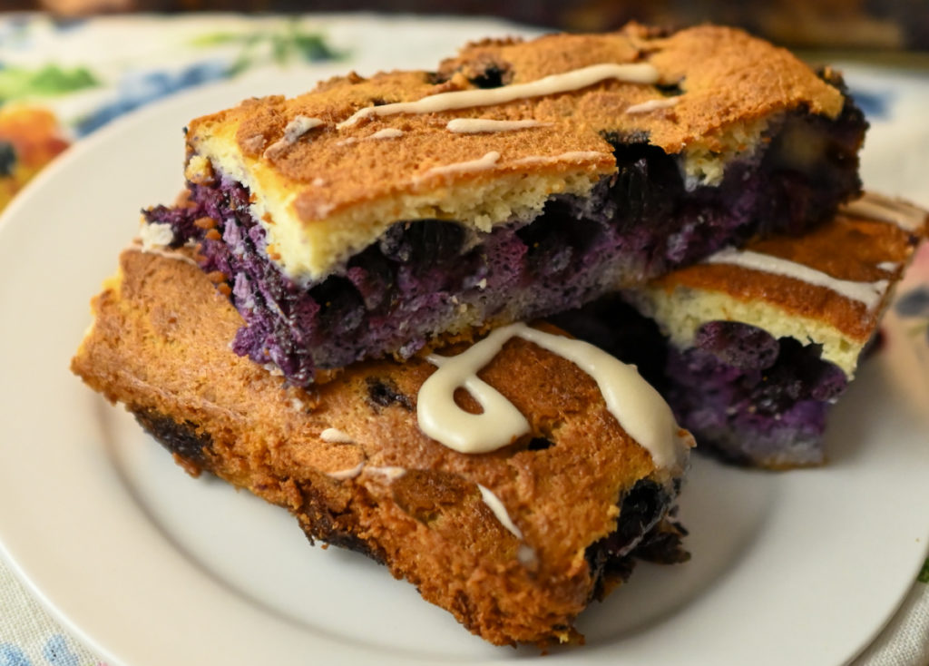 Keto blackberry bars stacked on a small white plate